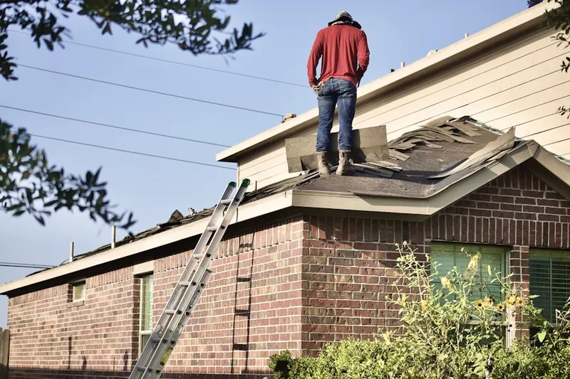 Professional roofer working on a residential roof in Blanchard